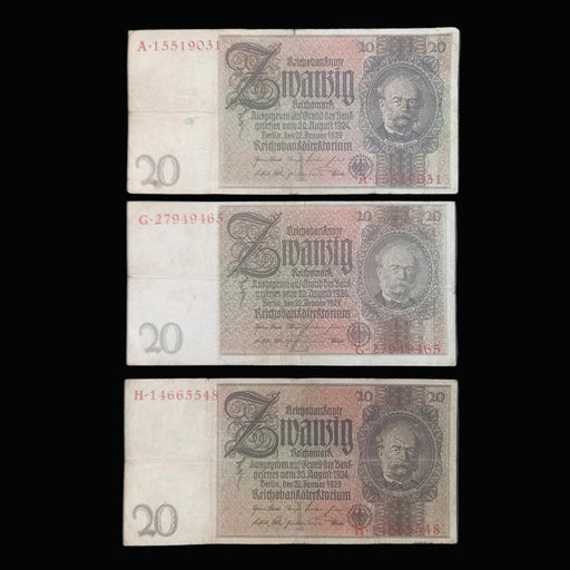 Three vintage German 20 Reichsmark banknotes are arranged vertically on a dark fabric background. Each note shows the portrait of Wilhelm Gustloff, serial numbers on the left, and ornate printed details in faded beige, brown, and gray tones.