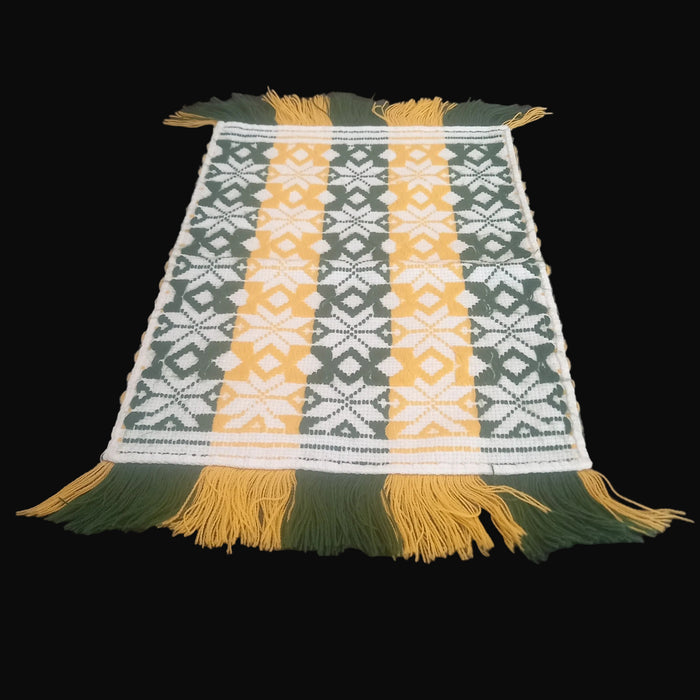Textile with green, yellow, and white pattern from hungary europe on a black surface