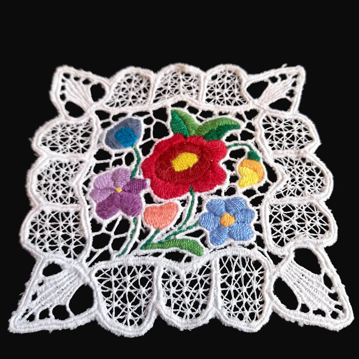 Decorative lace vintage doily with colorful flowers on a black background from Hungary Central Europe