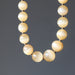 selenite  necklace with beige beads on a dark gray background