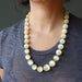 selenite necklace worn by a person against a dark background