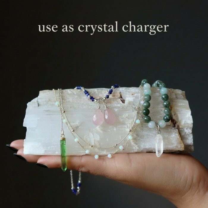 Hand holding crystal necklaces on a crystal base with text 'use as crystal charger' on a dark background
