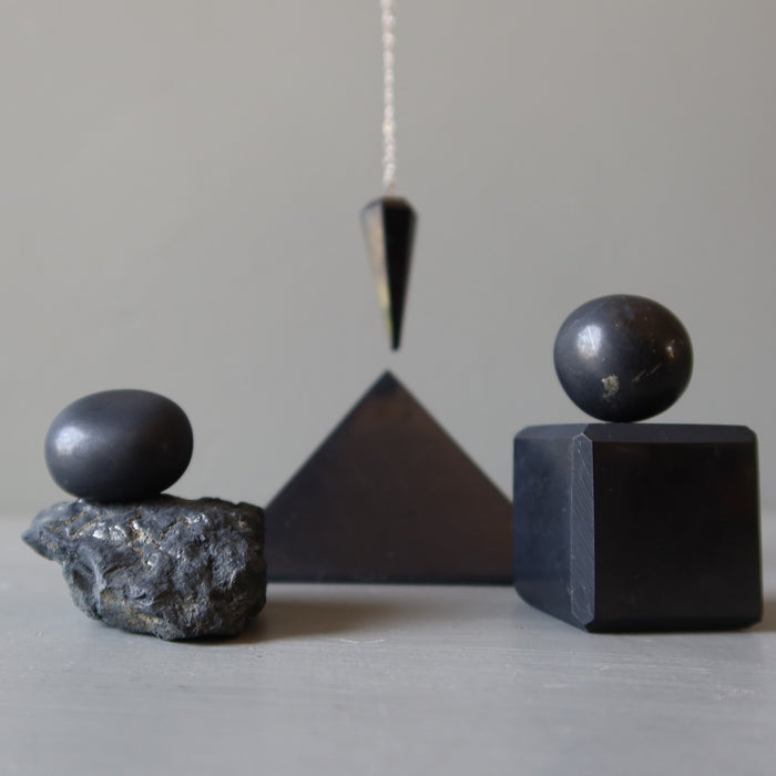 Shungite Geometric stone sculptures on a neutral background