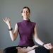 Woman in a purple shirt meditating with smoky quartz bracelets