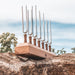 Set of tuning forks on a wooden block outdoors with a blurred natural background
