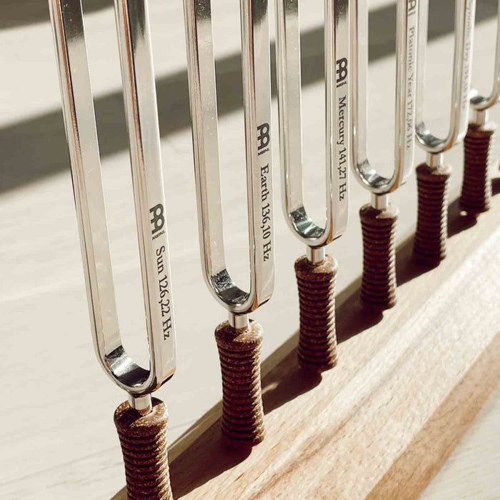 Set of tuning forks with brand names on a wooden surface