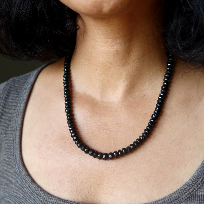 Person wearing a black Tourmaline beaded necklace with a neutral background