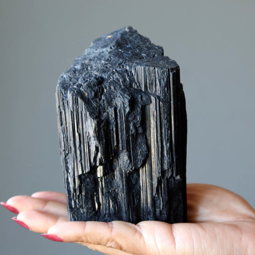 rough black tourmaline stone in hand