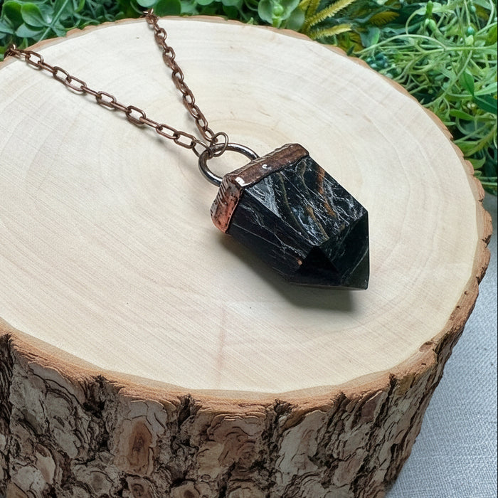 Necklace with a black stone pendant on a wooden surface