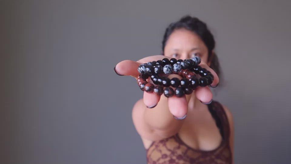 sheila of satin crystals holding out the obsidian trio bracelet set in her hand
