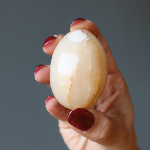 hand holding yellow aventurine egg