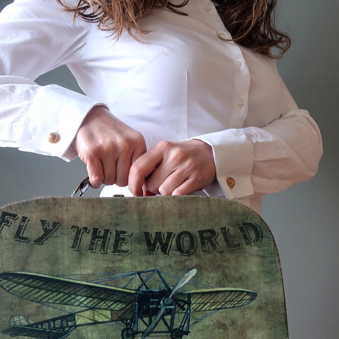 yellow crazy lace agate cufflinks modeled by a lady in french cuff shirt holding suitcase