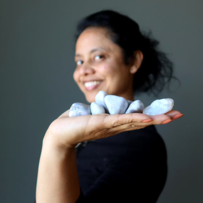 sheila of satin crystals holding a set of agate tumbled stones