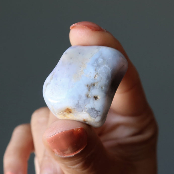 sheila of satin crystals holding an agate tumbled stone