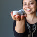 sheila of satin crystals holding a set of agate tumbled stones