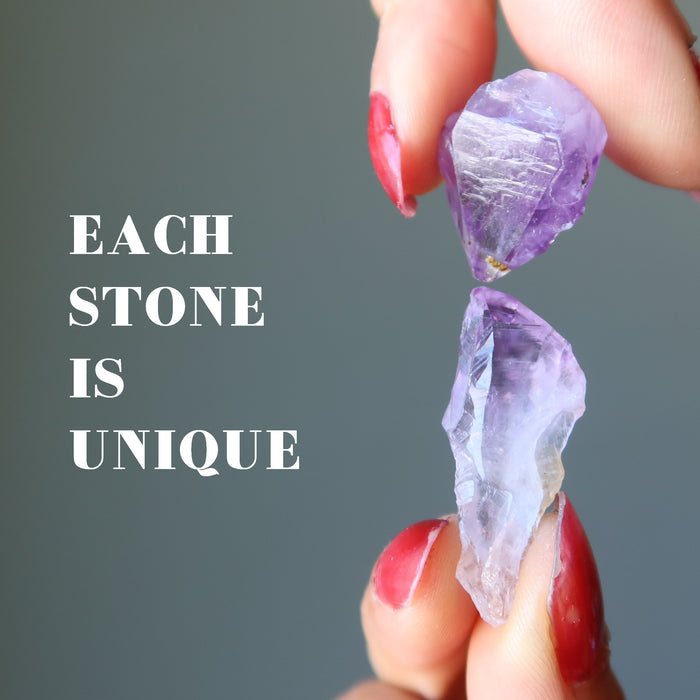 hands holding two amethyst points