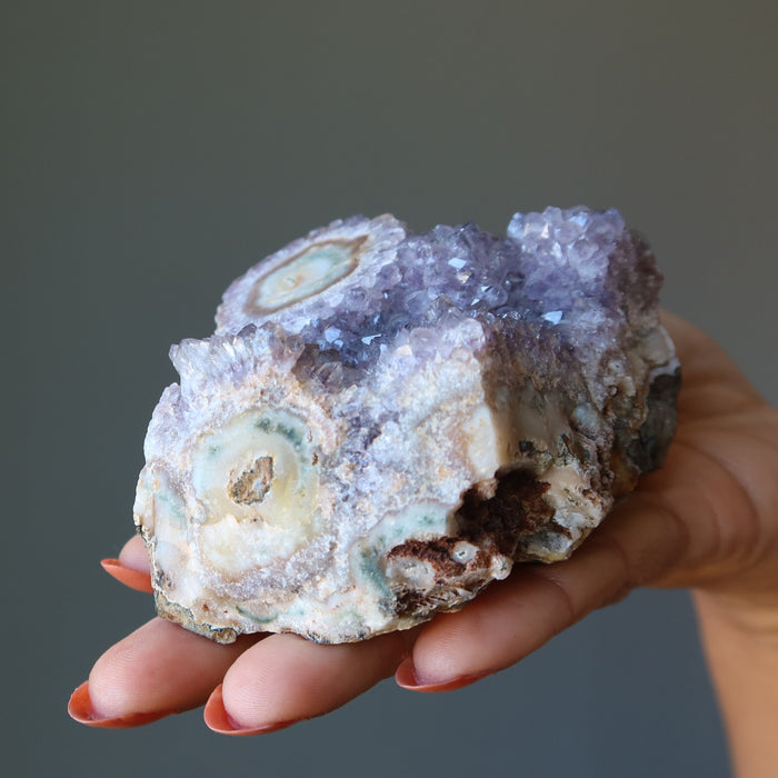 hand holding amethyst cluster geode