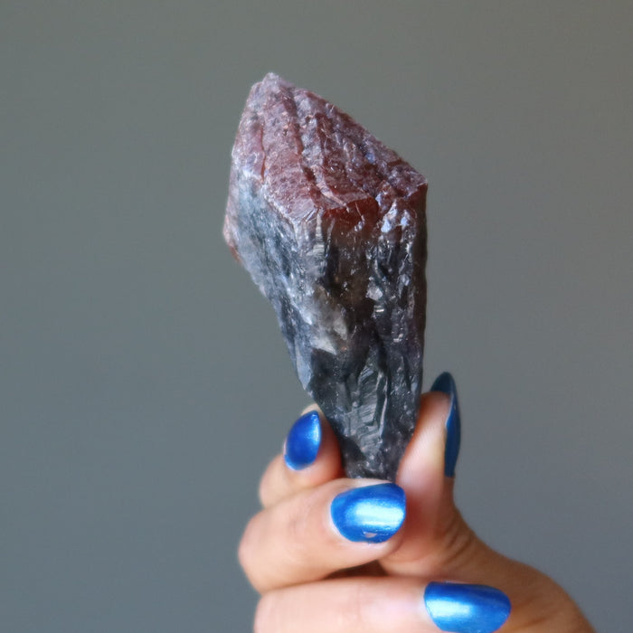 hand holding raw super 7 amethyst crystal point