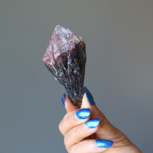 hand holding raw super 7 amethyst crystal point