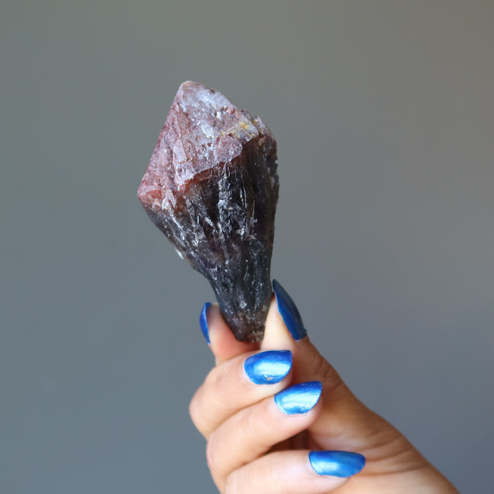hand holding raw super 7 amethyst crystal point