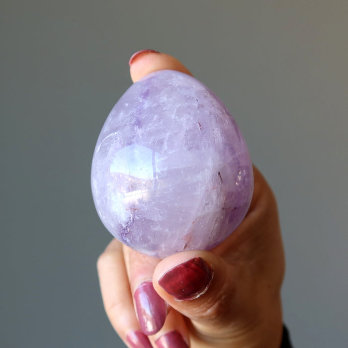 fingers holding Amethyst egg