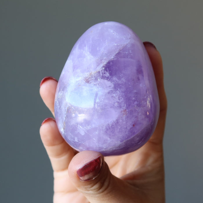 fingers are holding amethyst egg