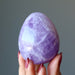 fingers are holding amethyst egg