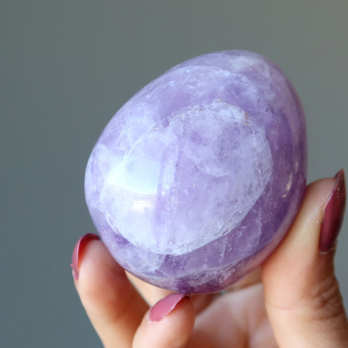 fingers are holding amethyst egg