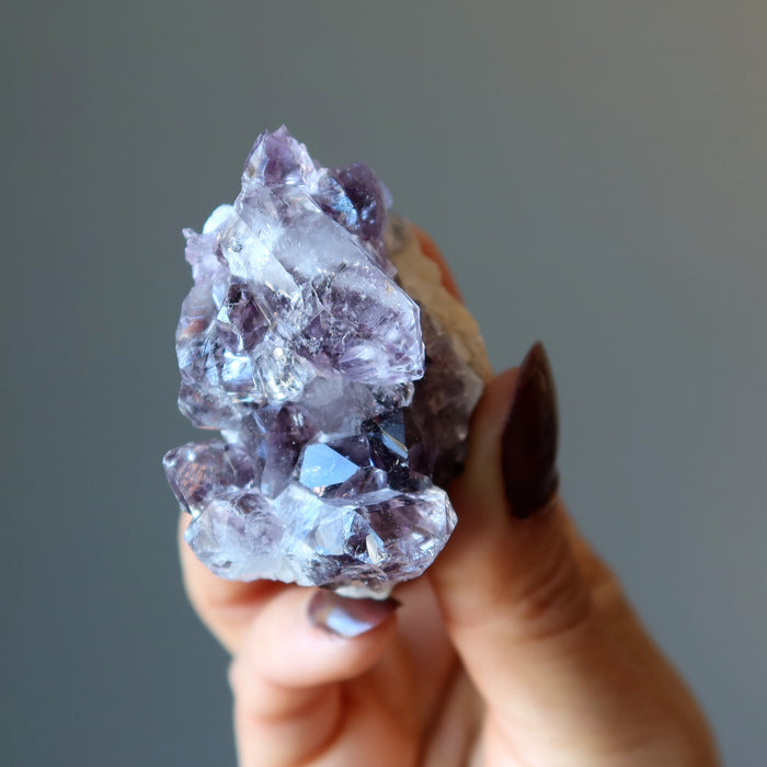 hand holding amethyst geode cluster