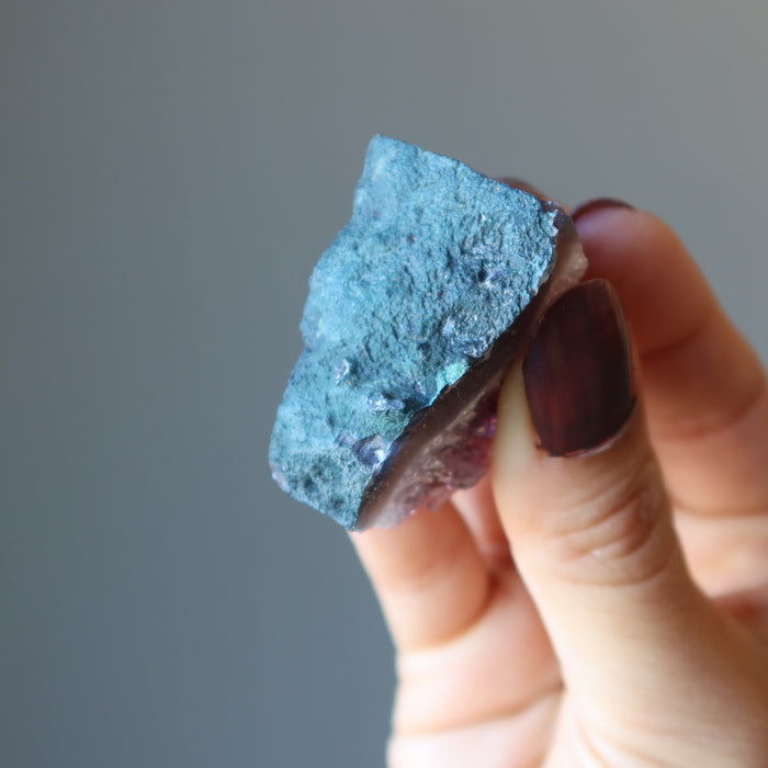 fingers holding amethyst cluster display back side