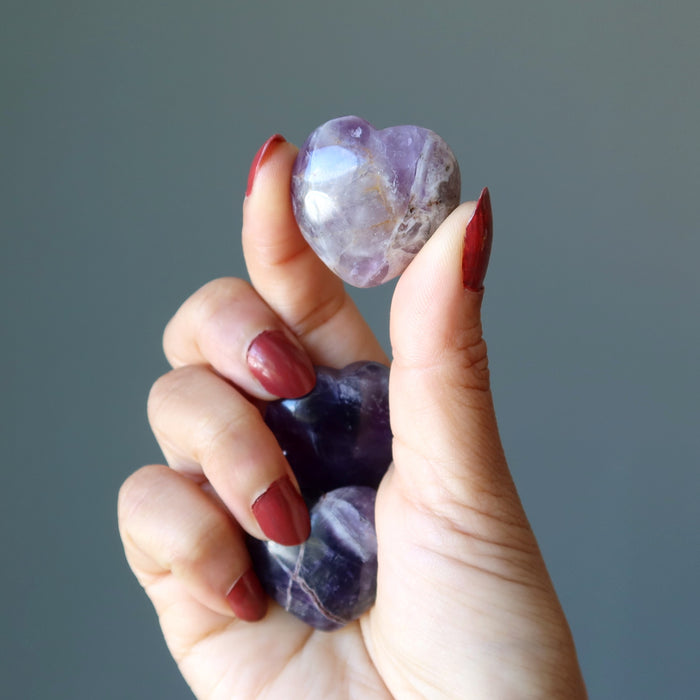 hand holding purple amethyst heart set