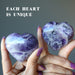 hands holding amethyst hearts to show each is unique