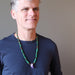 a male model wearing raw amethyst malachite beaded necklace