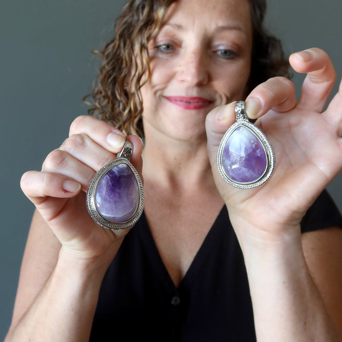 female model holding female model holding 2.3 x 1.5 inches Teardrop Purple Amethyst silver framed Pendant in each hand 