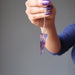 hand holding amethyst pendulum