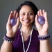sheila of satin crystals holding pair of purple amethyst polished ovalish palm stones