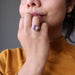 sheila of satin crystals wearing a faceted oval amethyst gemstone in silver ring