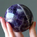 hand holding up a chevron amethyst sphere