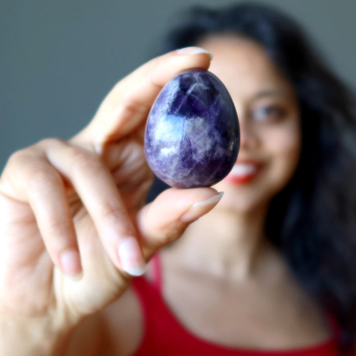 Sheila of Satin Crystals holding dark purple amethyst gemstone egg