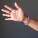 A woman's hand outstretched to show a round beaded purple ametrine crystal bracelet on her wrist
