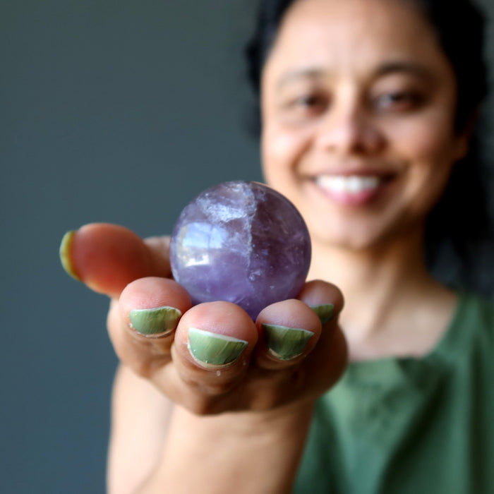 woman holding ametrine sphere