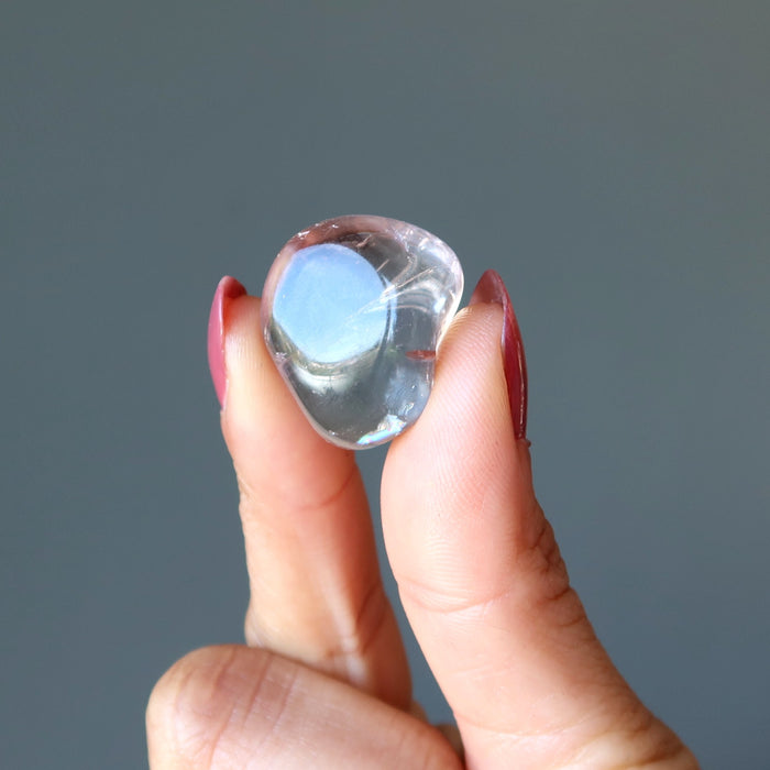 fingers holding amethyst citrine tumbled stone