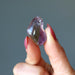 fingers holding amethyst citrine tumbled stone
