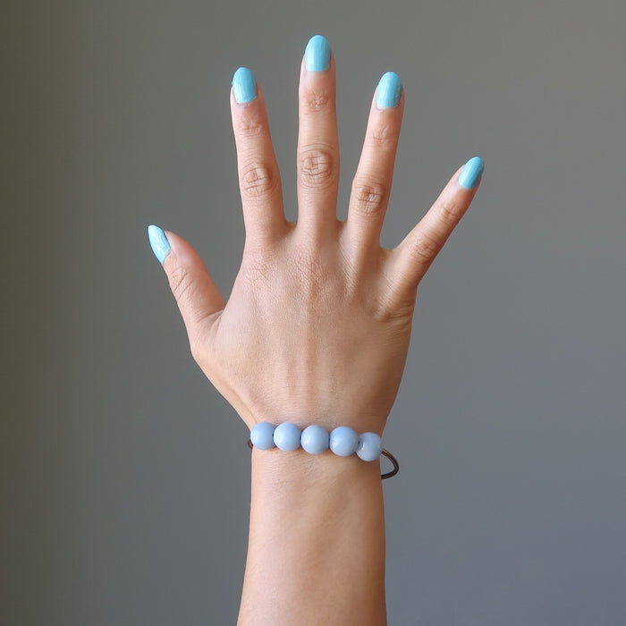 female hand modeling angelite brass stretch bracelet