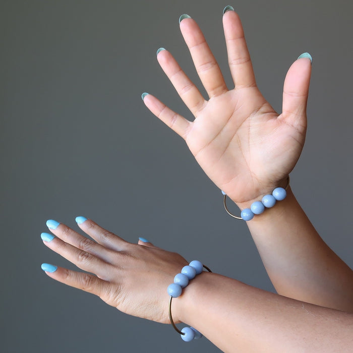 female hands modeling angelite brass stretch bracelet
