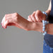 female hand modeling angelite brass stretch bracelet