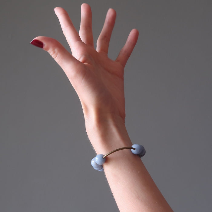 female hand modeling angelite brass stretch bracelet