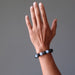 man's hand modeling blue angelite and black rainbow obsidian stretch bracelet