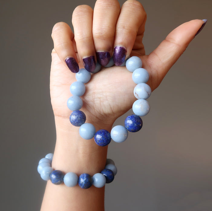 female hand holding and wearing lapis angelite bracelet