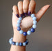 female hand holding and wearing lapis angelite bracelet